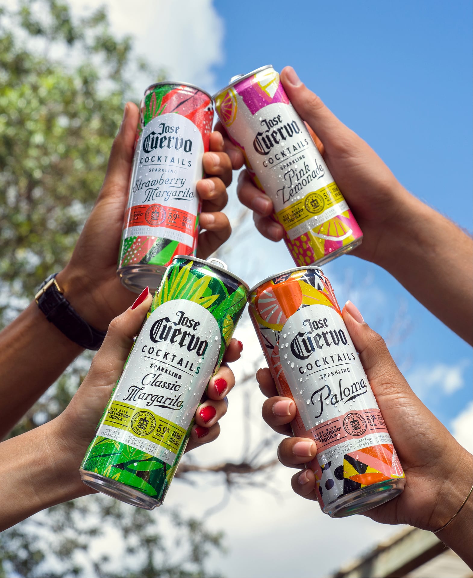 Toasting with Jose Cuervo Sparkling Cocktails cans including Strawberry Margarita, Classic Margarita, Paloma, and Pink Lemonade outdoors